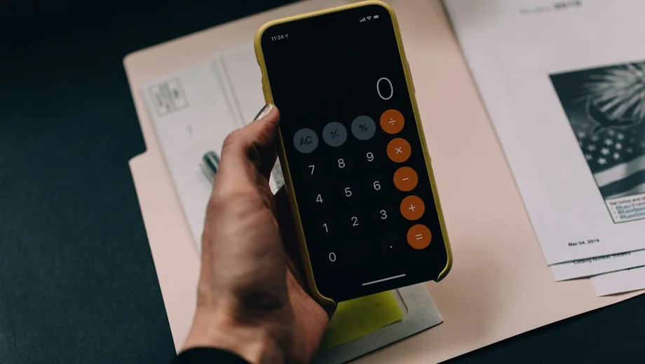 Persona usando una calculadora sobre documentos