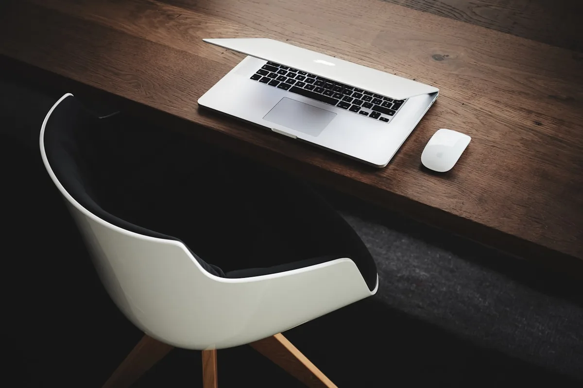 Escritorio con laptop abierta para redactar una oferta de empleo