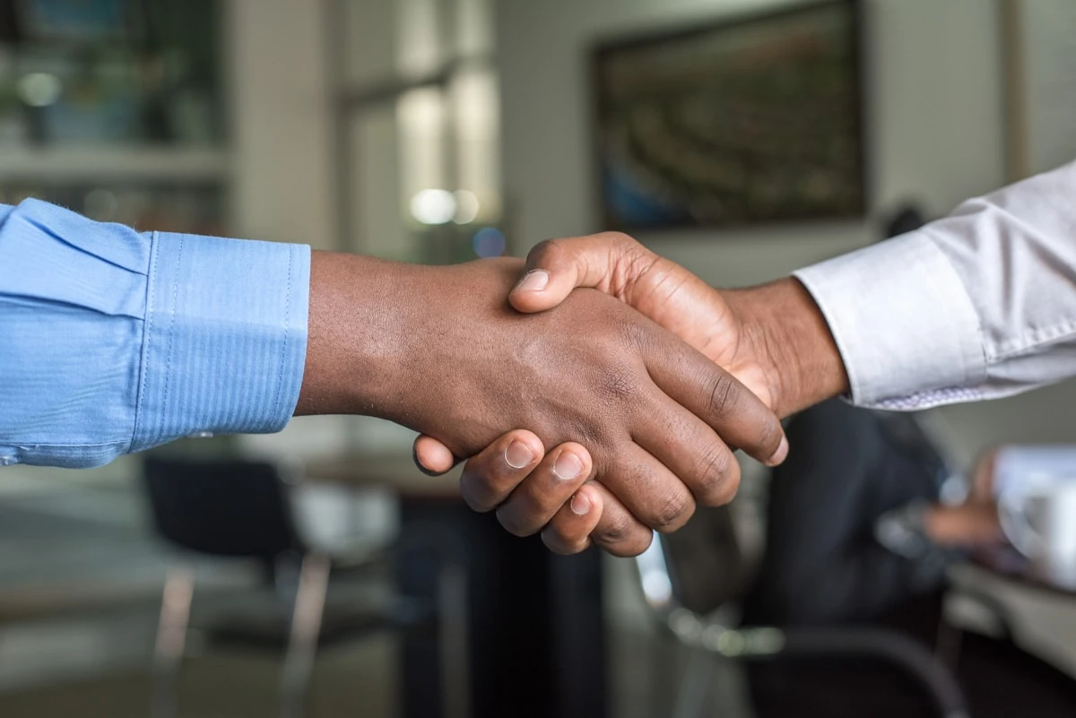 Dos personas se dan la mano en una oficina tras una entrevista de trabajo