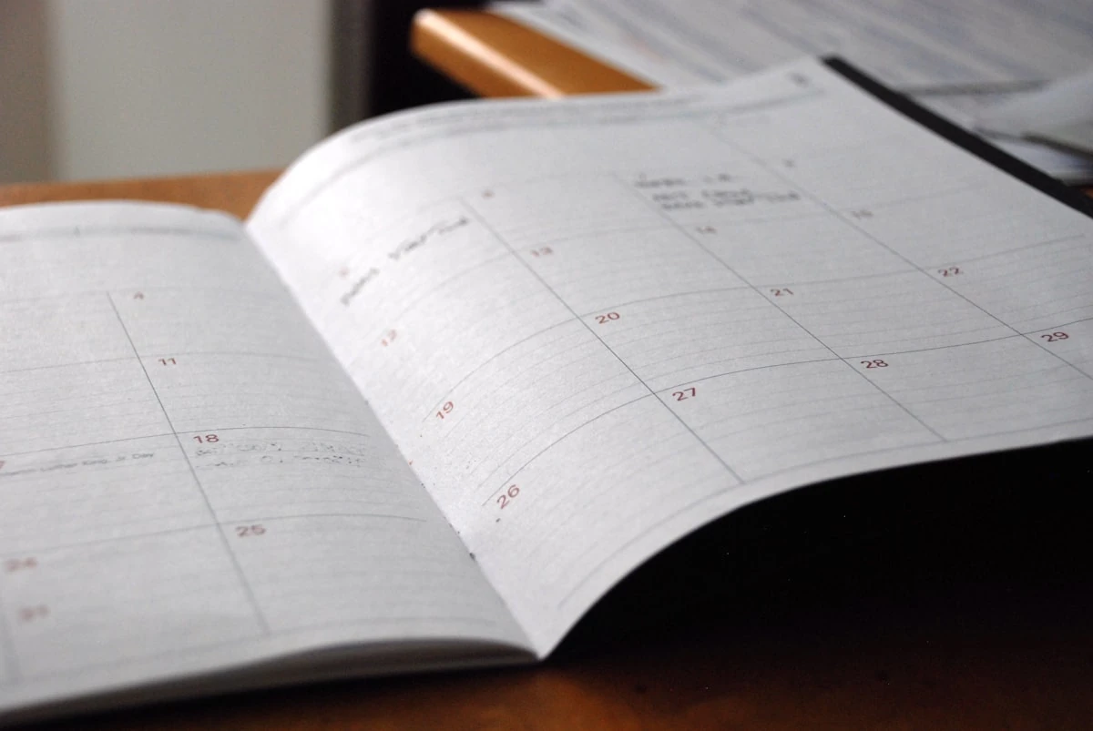 Agenda de papel abierta con los festivos del calendario laboral 2026 marcados en rojo